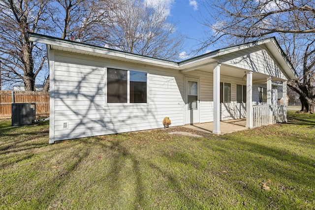 view of front of property featuring covered porch, a front lawn, and central air condition unit