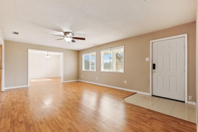 entrance foyer featuring a textured ceiling, light hardwood / wood-style floors, and ceiling fan