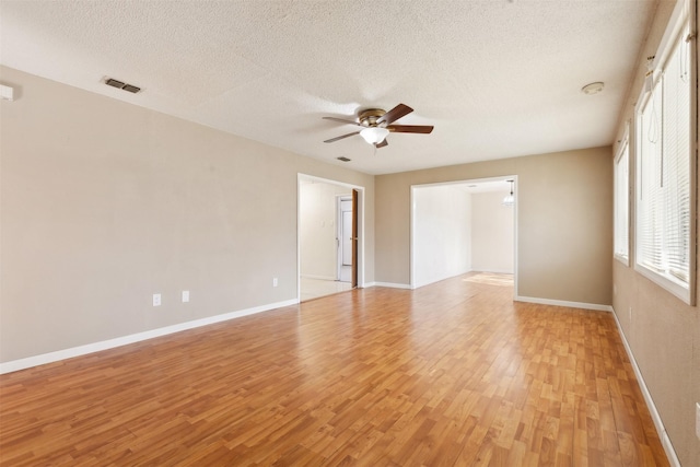 unfurnished room featuring ceiling fan, light hardwood / wood-style floors, and a textured ceiling