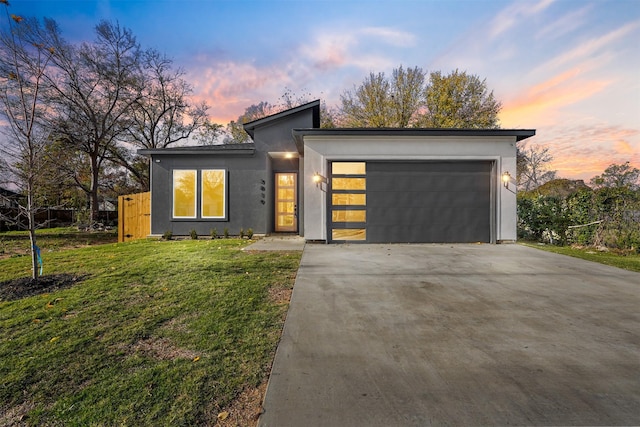 view of front of property featuring a garage and a lawn