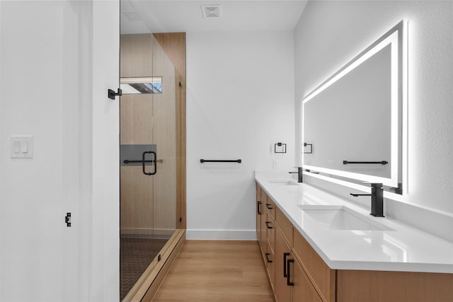 bathroom featuring hardwood / wood-style floors, vanity, and walk in shower