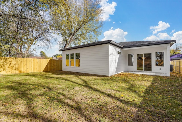 back of property with a lawn and central air condition unit