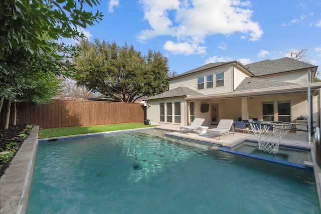 rear view of house with a fenced in pool and a patio area