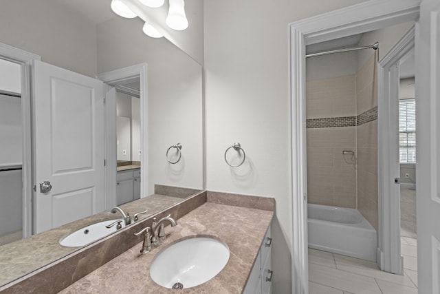 bathroom with tile patterned flooring, vanity, and tiled shower / bath combo