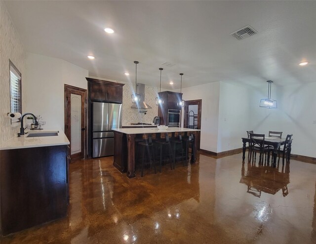 kitchen featuring hanging light fixtures, sink, wall chimney exhaust hood, and stainless steel appliances