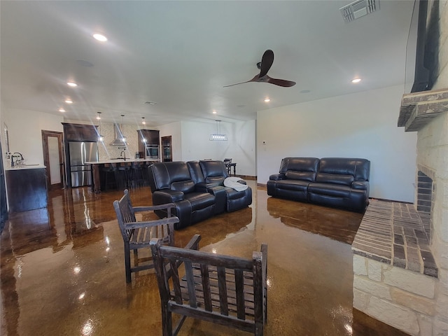 living room with ceiling fan and a fireplace