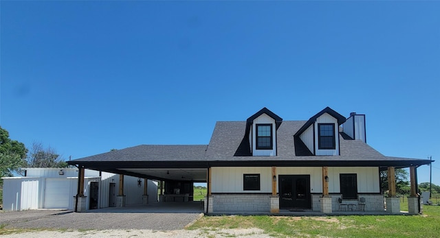 view of front of house featuring covered porch, a carport, and an outdoor structure