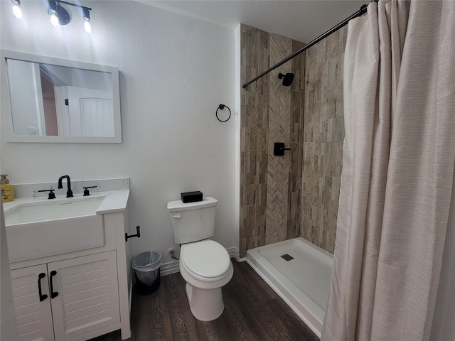 bathroom featuring a shower with shower curtain, hardwood / wood-style floors, vanity, and toilet