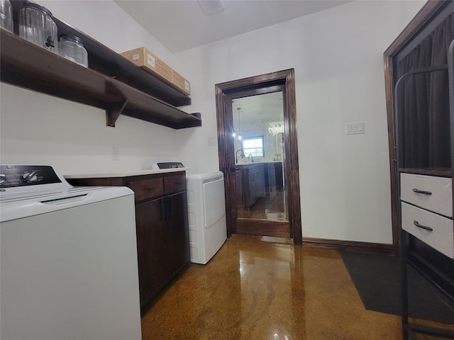 laundry room with separate washer and dryer and sink