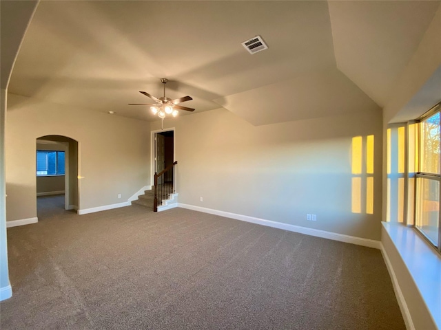 empty room featuring dark carpet, ceiling fan, and vaulted ceiling