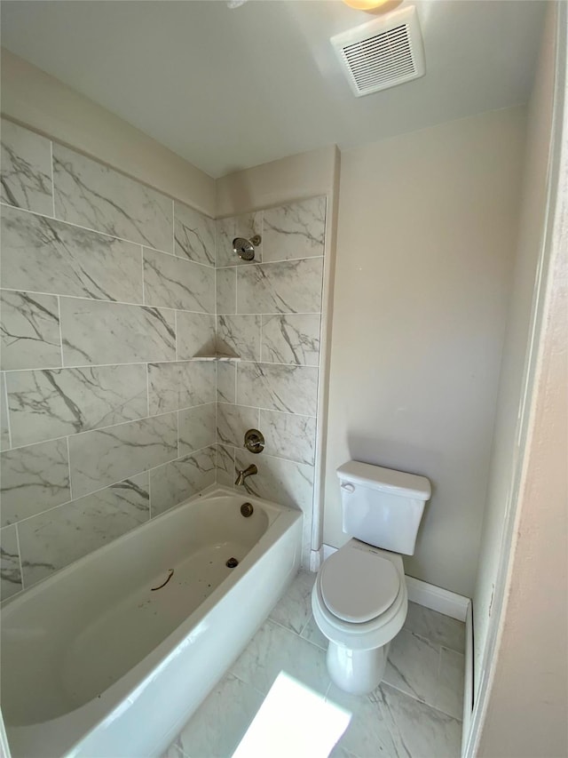 bathroom with toilet and tiled shower / bath combo