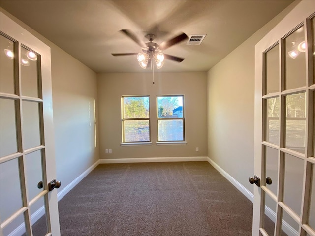 empty room with ceiling fan and dark carpet