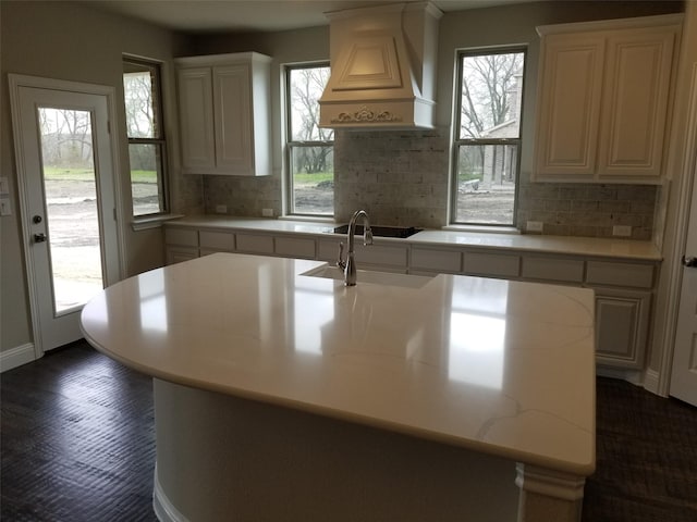 kitchen with custom exhaust hood, a wealth of natural light, and tasteful backsplash