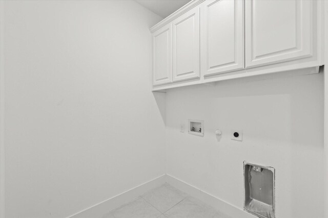 laundry area featuring cabinets, washer hookup, electric dryer hookup, light tile patterned floors, and hookup for a gas dryer