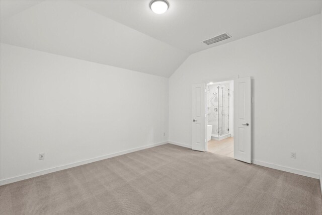 interior space featuring lofted ceiling and light carpet