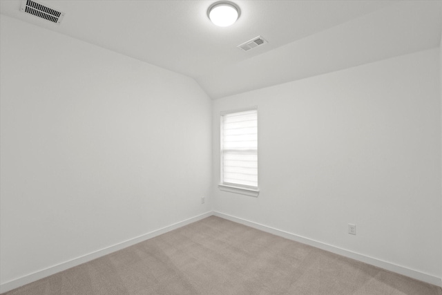 carpeted empty room with lofted ceiling