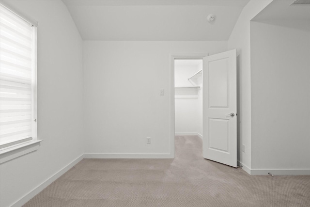 carpeted spare room featuring lofted ceiling