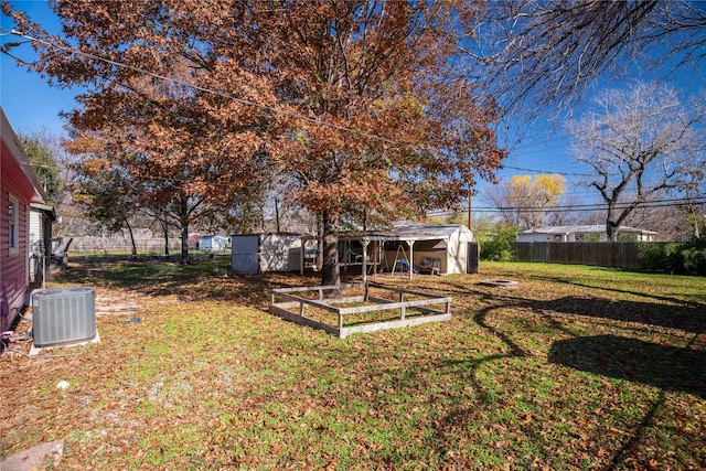 view of yard featuring central AC unit and a storage unit