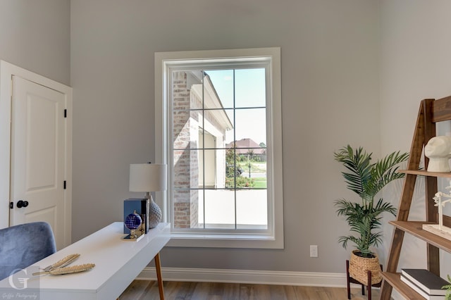 home office with hardwood / wood-style floors and a healthy amount of sunlight