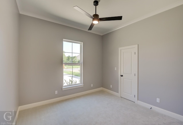 unfurnished room featuring ceiling fan, light colored carpet, and ornamental molding