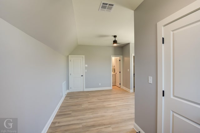 corridor featuring lofted ceiling and light wood-type flooring