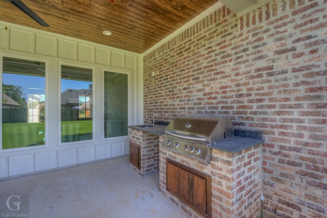 view of patio with an outdoor kitchen, area for grilling, ceiling fan, and sink