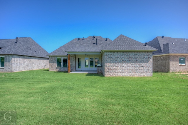 back of house featuring a lawn and a patio