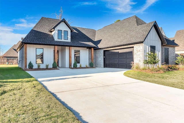 modern inspired farmhouse featuring a front lawn and a garage