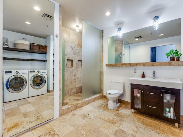 bathroom with a shower with shower door, toilet, separate washer and dryer, and vanity