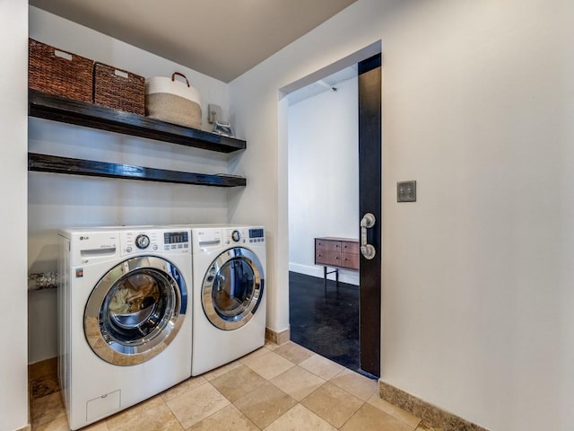 clothes washing area featuring light tile patterned floors and washing machine and dryer