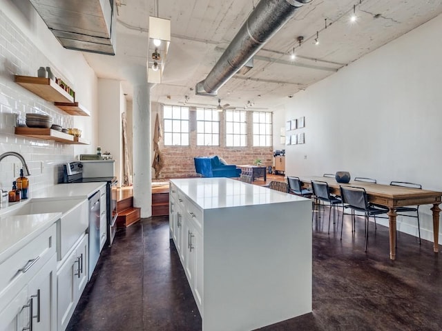 kitchen featuring a center island, white cabinets, sink, hanging light fixtures, and stainless steel electric range oven