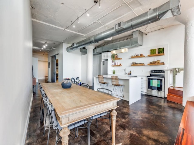 dining space featuring concrete floors, visible vents, and indoor wet bar