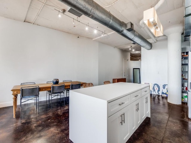 kitchen with white cabinets, decorative light fixtures, and a center island