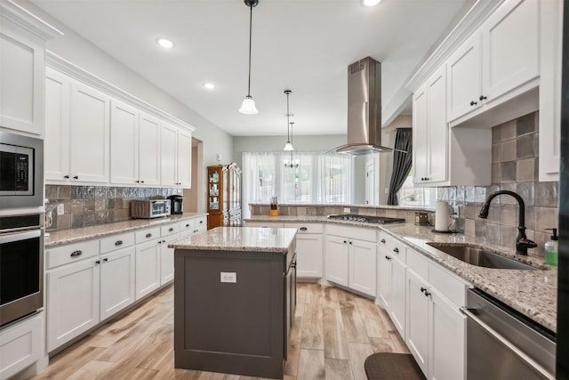 kitchen with a center island, white cabinets, sink, appliances with stainless steel finishes, and island range hood