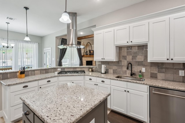 kitchen featuring stainless steel dishwasher, gas stovetop, sink, white cabinets, and hanging light fixtures