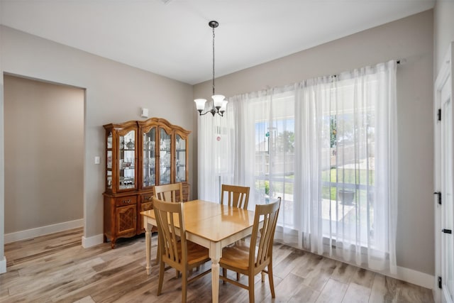 dining room with light hardwood / wood-style flooring and a notable chandelier