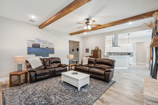 living room with beam ceiling, light wood-type flooring, and ceiling fan