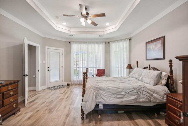 bedroom with ceiling fan, light wood-type flooring, ornamental molding, and a tray ceiling