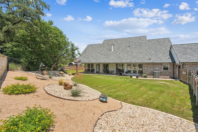 back of property featuring central AC unit, a patio area, and a lawn