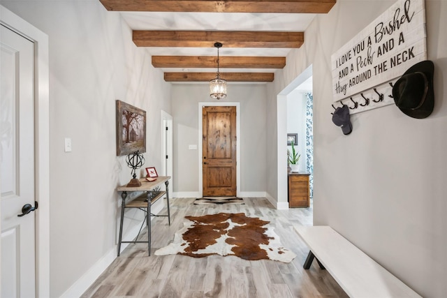 foyer entrance featuring a chandelier, beamed ceiling, and light hardwood / wood-style floors