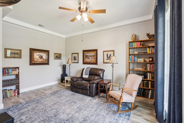 living area with ceiling fan and light hardwood / wood-style flooring