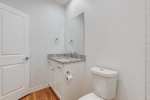 bathroom featuring hardwood / wood-style flooring, vanity, and toilet