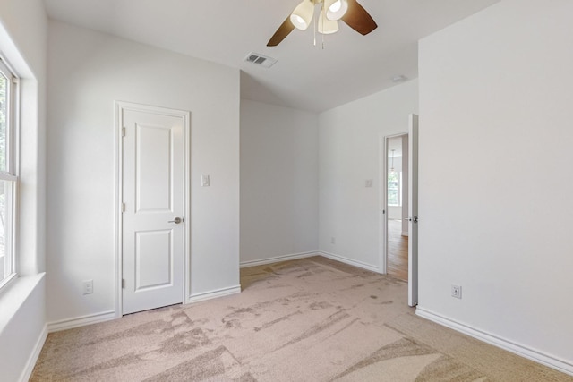 carpeted spare room featuring ceiling fan