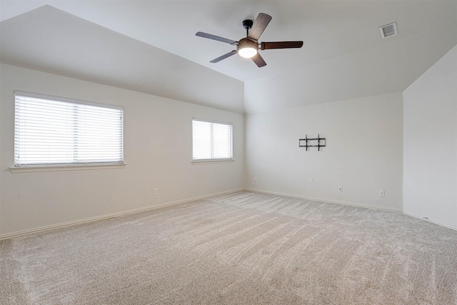 carpeted spare room featuring vaulted ceiling and ceiling fan