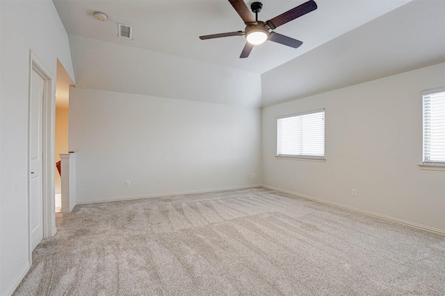 carpeted empty room with ceiling fan, lofted ceiling, and a healthy amount of sunlight