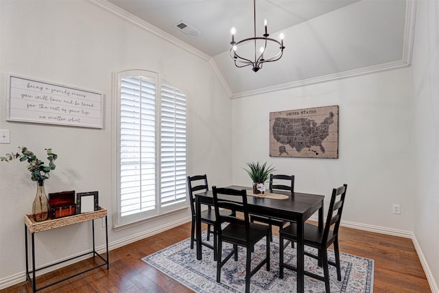 dining space with crown molding, dark wood-type flooring, a chandelier, and vaulted ceiling