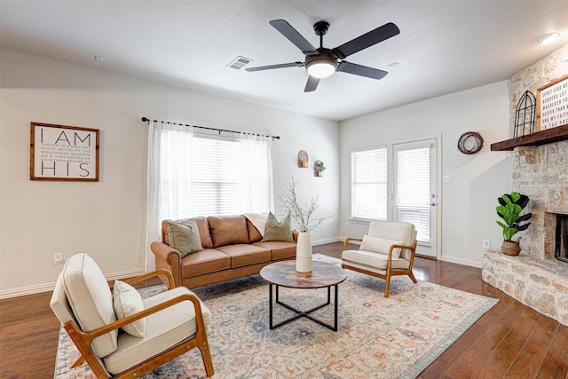 living room featuring ceiling fan, a fireplace, and dark hardwood / wood-style flooring