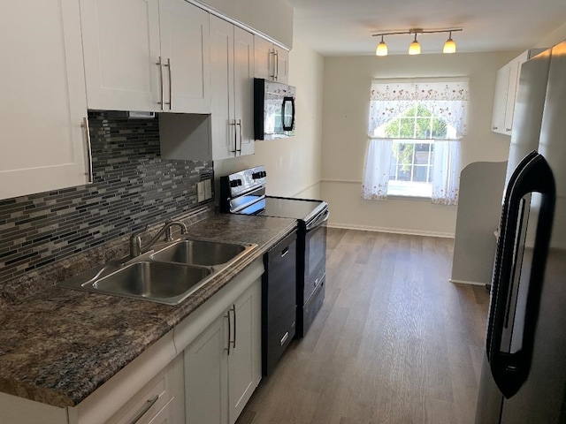 kitchen with tasteful backsplash, white cabinets, sink, and black appliances