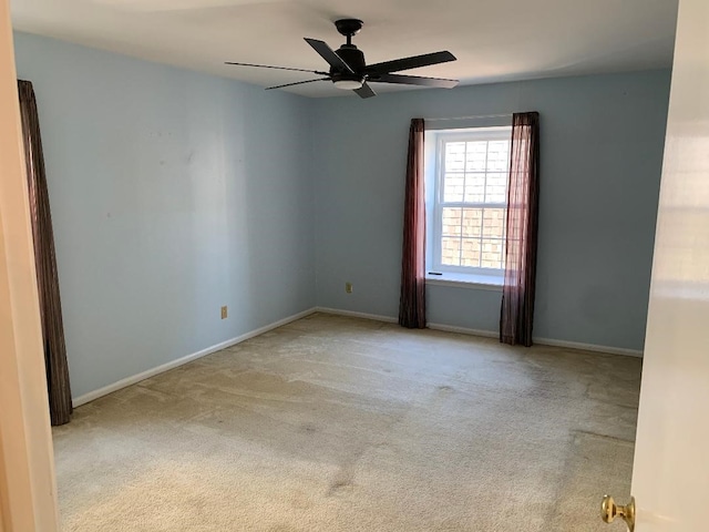 spare room with light colored carpet and ceiling fan