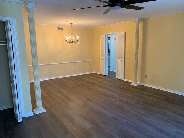 empty room featuring decorative columns, crown molding, ceiling fan with notable chandelier, and dark hardwood / wood-style floors